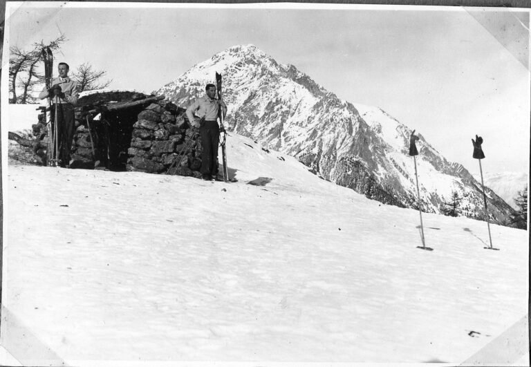 Deux chasseurs alpins skis aux pieds devant un abri de pierre en montagne près de Briançon, en février 1935