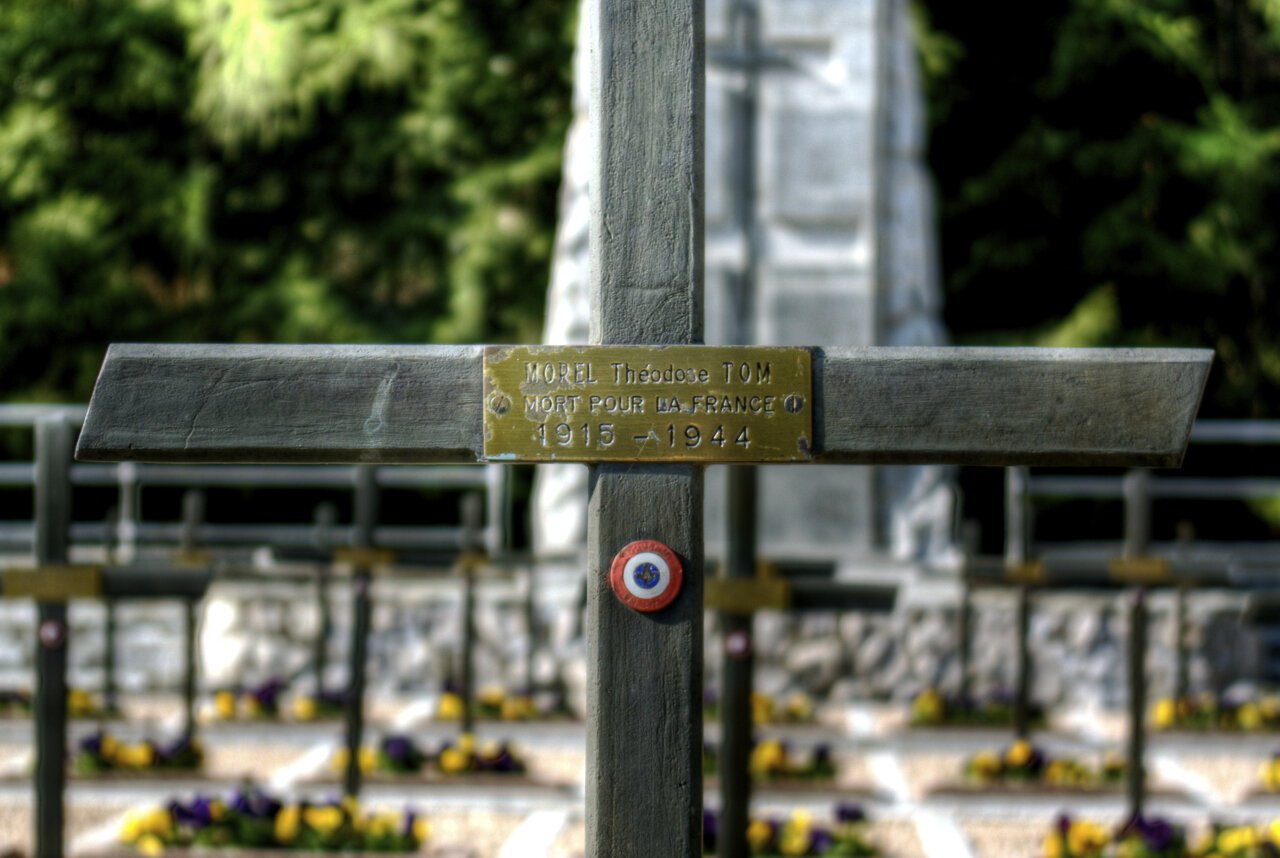 Croix de bois portant le nom de Théodose Tom Morel sur sa sépulture à la nécropole nationale des Glières
