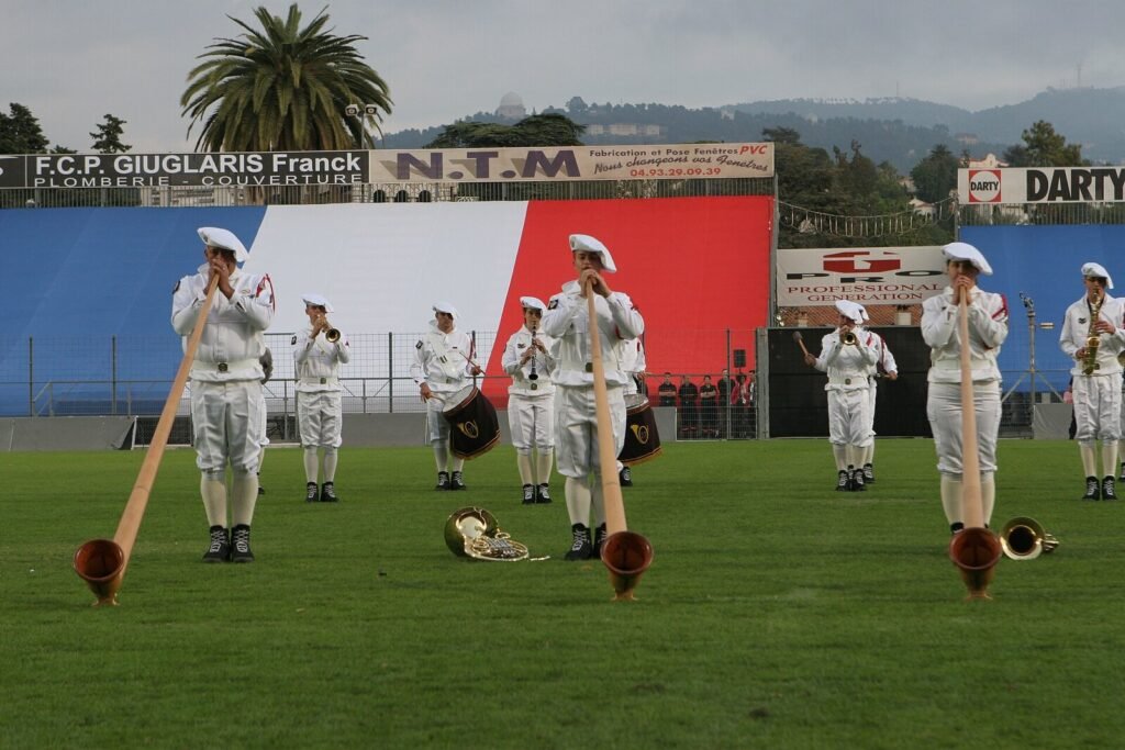 Musicien de la fanfare du 27e bataillon de chasseurs alpins jouant du cor des Alpes en tenue de cérémonie