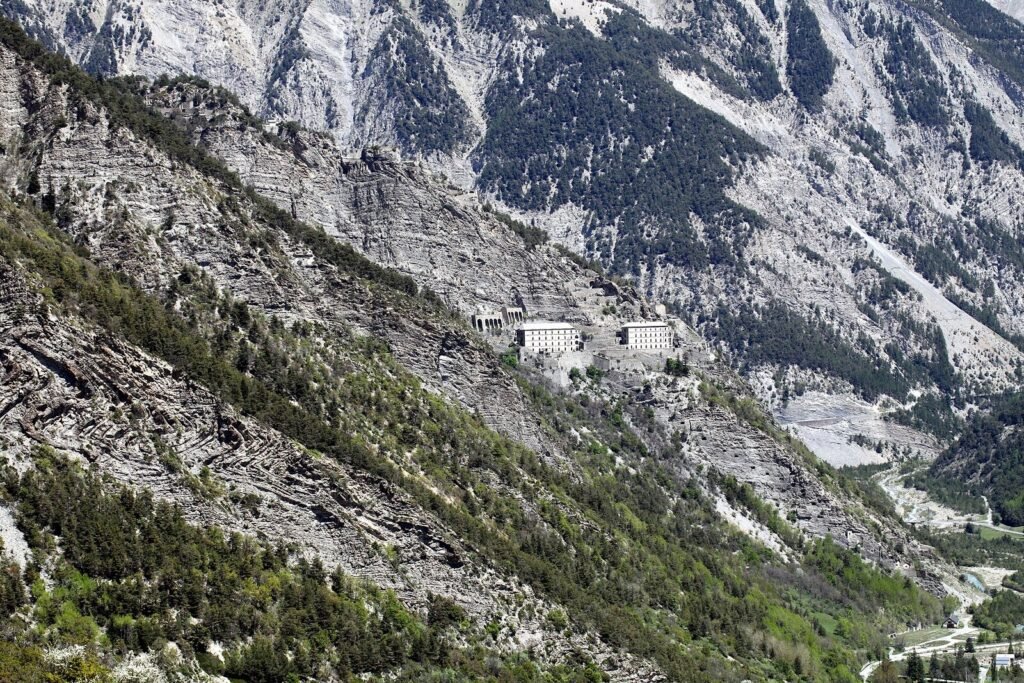 Le fort de Tournoux étagé sur un éperon rocheux boisé au-dessus de la vallée de l'Ubaye